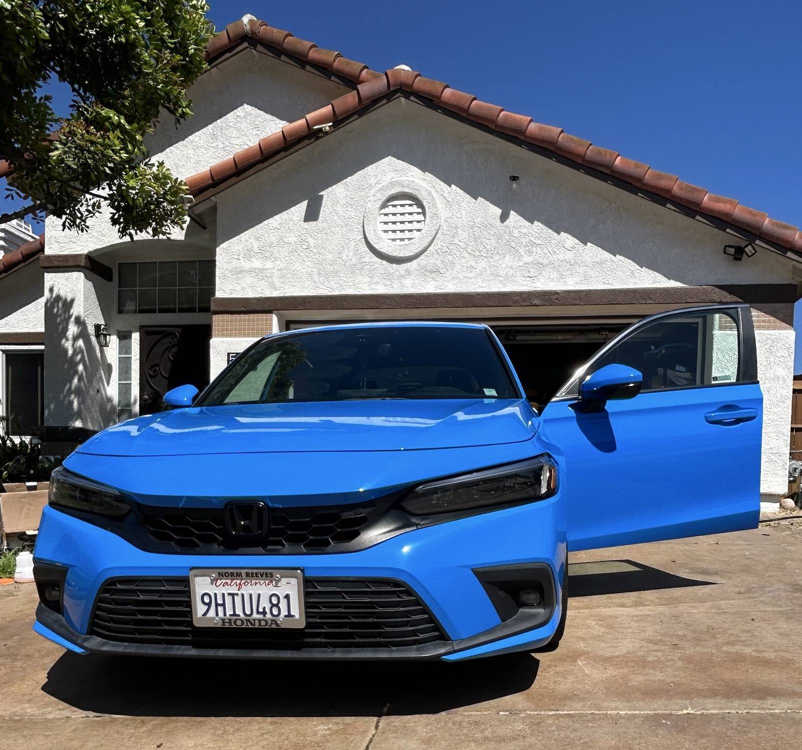Bright blue Honda Civic freshly detailed inside and out in a San Diego driveway